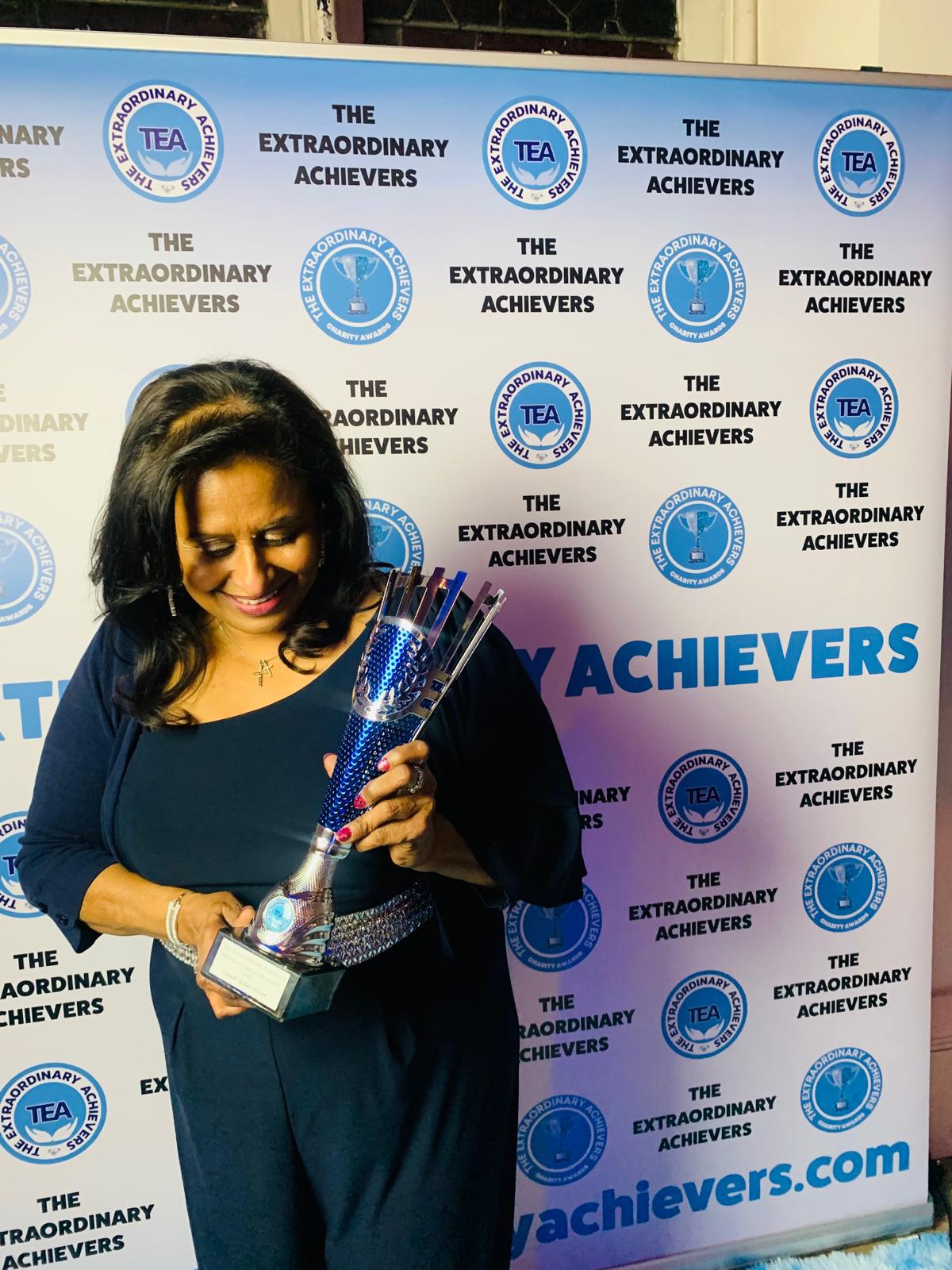 Usha Oliver holding The Extraordinary Achievers charity award